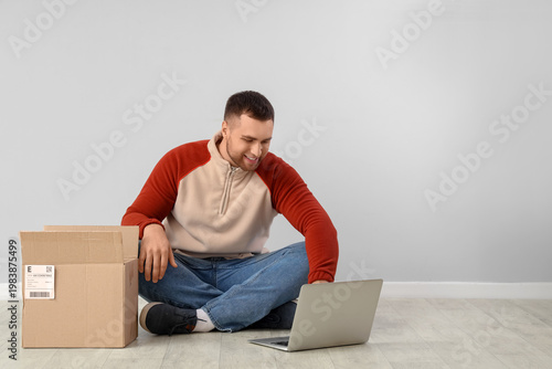 Young man with parcel using...
