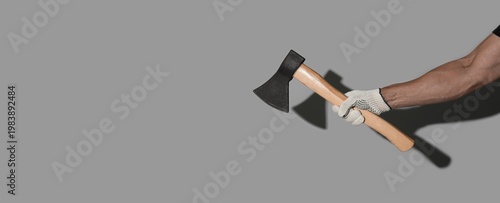 Male hand holding ax on gre...