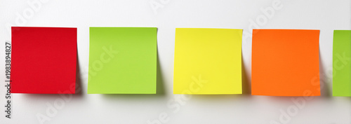 4 pieces of colored paper notes with a red pin isolated on a white background.