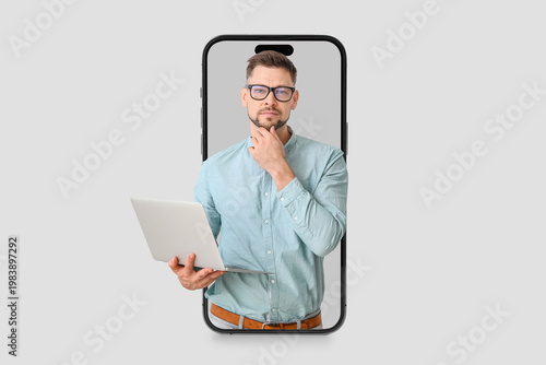 Male psychologist with laptop on light background