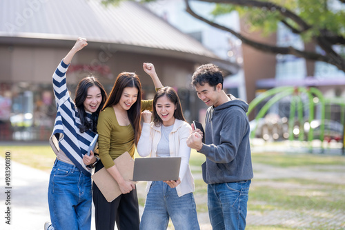 Group of students celebrating online success together outdoors