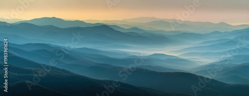 Panoramic vista of layered blue ridge mountains at sunrise, mist in valleys