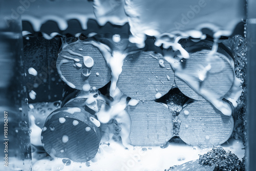 Obraz na plátně Close-up of a group of metal rods being cut by a band saw machine with liquid coolant application