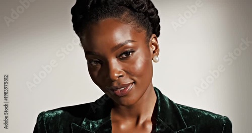 Elegant woman in a green velvet blazer smiling softly against a neutral background
