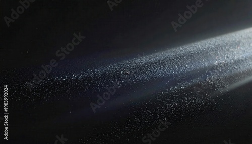 暗闇の中に差し込む一筋の明るい光線が、空気中を漂う無数の埃や微粒子を照らし出し、まるで宇宙の星々のように幻想的でキラキラと輝く様子を捉えた、シネマティックで抽象的なテクスチャ背景素材。