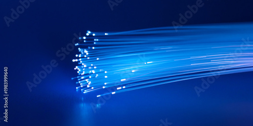 Fiber Optic Cables Emitting Bright Light Streams on Dark Blue Background