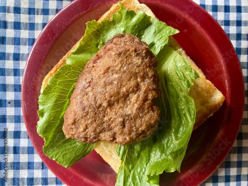 Spicy beef patty with fresh lettuce on a slice of toast
