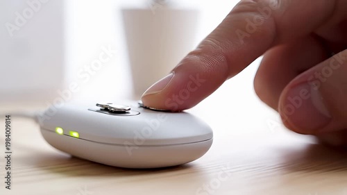 Person's finger about to press button on white wireless controller