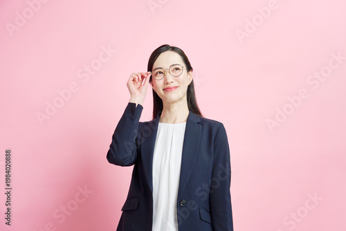 Tableau sur toile メガネに手を添えるビジネスウーマン ピンク背