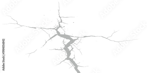 A detailed close up view of a stark grey crack spreading across a plain white background surface.