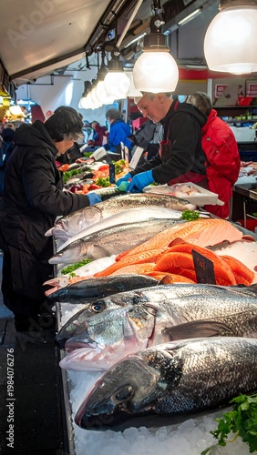 A busy fish market scene with various fresh seafood on display