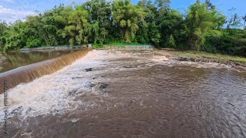 Aerial 4K view of a powerful river flowing with muddy brown water after heavy