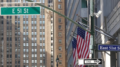 New York City Park Avenue, street sign in Manhattan Midtown, United States. Urban road sign, traffic sign in NYC, USA. Building architecture near Grand Central. One way arrow and American flag.