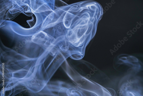 Abstract blue smoke against a dark background, showcasing intricate patterns and textures