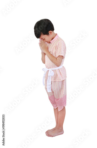 Charming young Asian boy dressed in traditional pink Thai costume performing the 