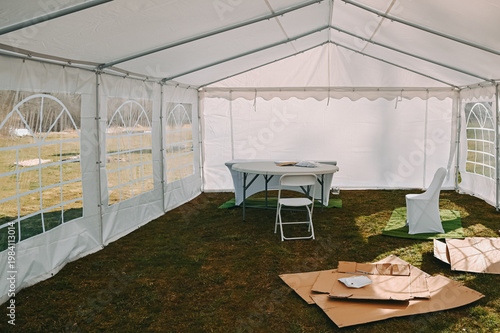 Empty Event Tent Setup with Table and Chairs Outdoors