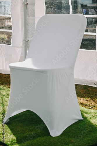 White Covered Event Chair in Outdoor Tent Setup