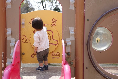 Foto Back View of a Toddler Playing with Educational Panels at a Park