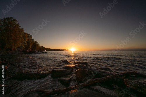Golden hour light reflecting on lake water and shore Silver City