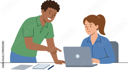 Two people collaborating on a laptop at a desk with papers