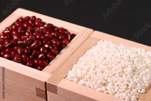 黒背景の枡に山盛りに盛られた小豆ともち米