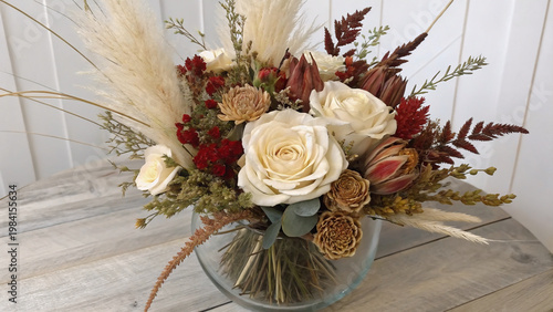 Rangkaian bunga kering yang elegan dalam nuansa netral di atas permukaan putih.
