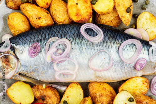 Plate with salted herring and baked potatoes
