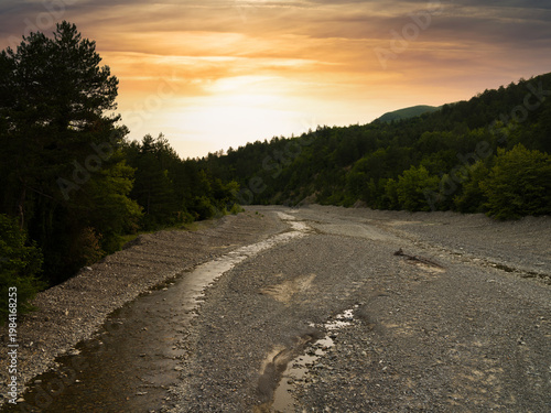 Dry riverbed. Dry season in a forested area. Sunset.
