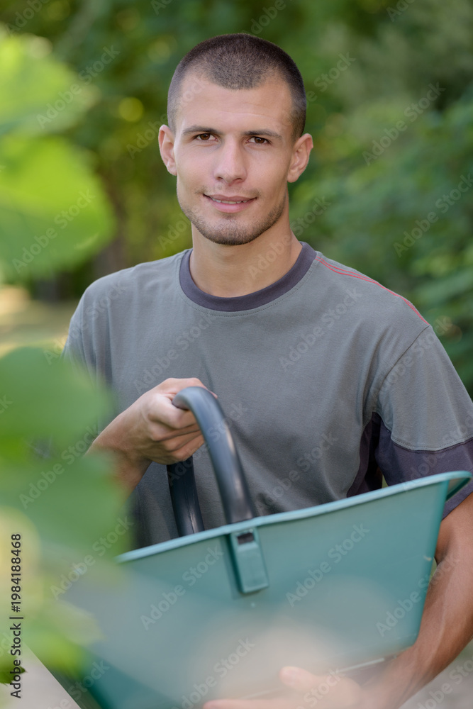 Naklejka premium portrait of young grape harvester holding trug