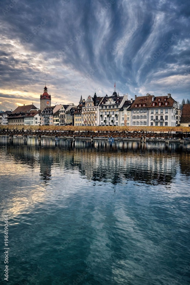 Obraz premium Beautiful European city waterfront with reflections and dramatic cloudy sky