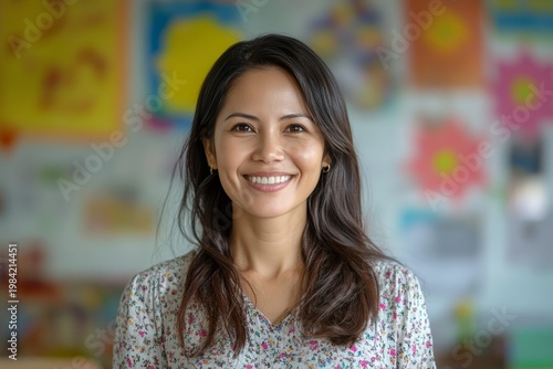 Smiling Asian Woman in Front of Colorful Classroom Backdrop