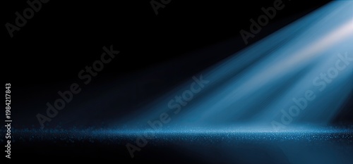 A dramatic spotlight illuminates a dark, textured surface, creating a sense of mystery and focus.