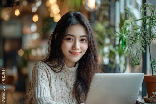 Smiling Young Woman Working on Laptop in Cozy Cafe