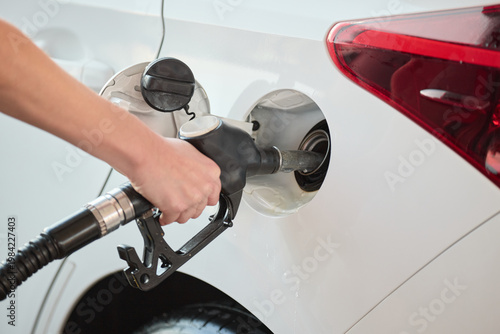 Obraz na plátně Close up of a person refueling a car with a fuel nozzle at a gas station