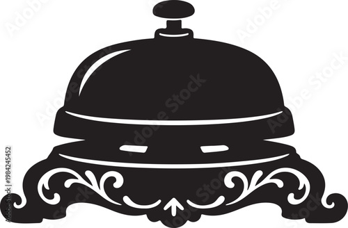 A black service bell with decorative design on the base sits on a table indoors.