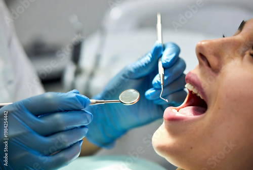 A dentist is examining a patient’s mouth with a dental mirror and probe. It's taking place in a dental office.