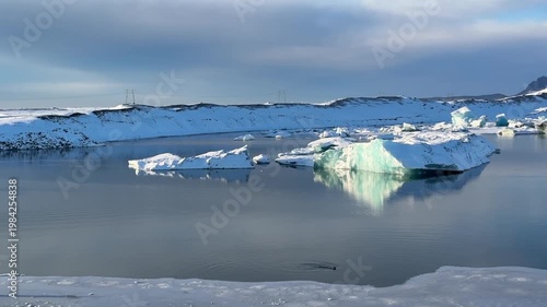 Luminous icebergs drifting on Jökullsarlon glacier lake in southern Iceland