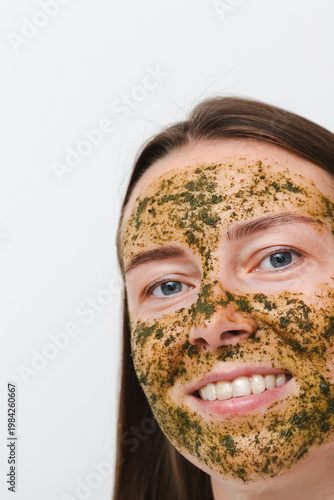 Wallpaper Mural Portrait of young girl or woman with green natural homemade cosmetic mask on her face with white background. Concept of self-care at home or in salon. Vertical photo Torontodigital.ca