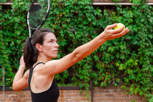 Wallpaper Mural Woman preparing tennis serve on outdoor clay court. The image represents concentration, determination, focus, and the pursuit of personal excellence through sport and discipline. Torontodigital.ca