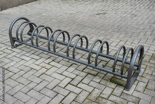 Wallpaper Mural Steel Loop Bike Rack By Building Entrance On Tiled Pavement, Compact Parking Solution With Repetitive Arcs, Daytime Neutral Lighting And Urban Utility Vibe, Ideal For Commuter Parking And Facility Torontodigital.ca
