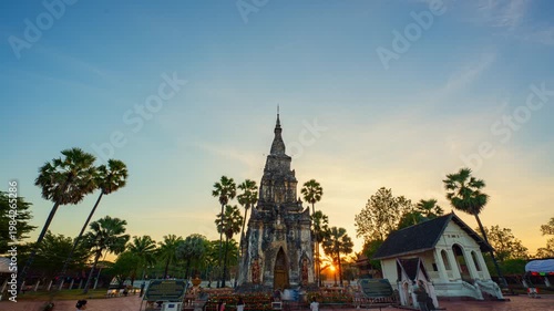 A serene evening scene of a Pha That Phoun historic Buddhist captured during blue hour, featuring dramatic sky colors and gentle movement of visitors. The composition blends sacred architecture.