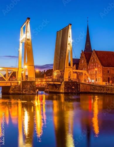 Drawbridge open over water, glowing against the dusk sky. Tall brick buildings behind it