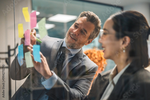 Business people collaborating on ideas using sticky notes