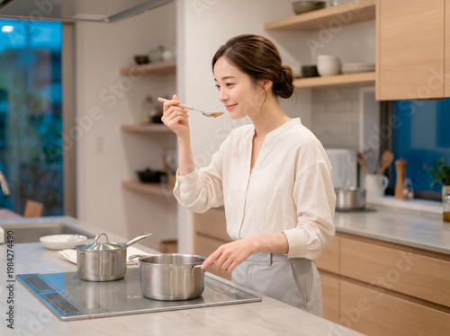 キッチンで味見をする女性