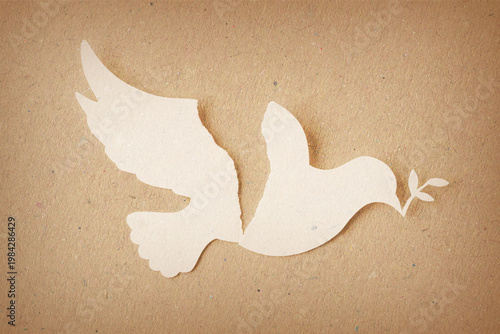 Torn paper dove holding an olive branch on recycled paper background - Concept of war, its global impacts and environmental damage
