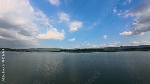 Aerial view of Sutami Dam at sunset with golden reflections on the reservoir water