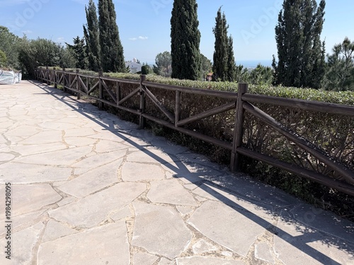 Stone pavement pathway with wooden fence in park