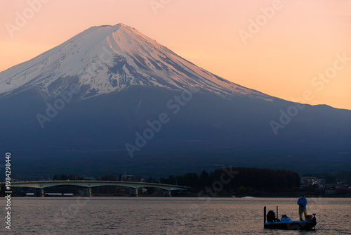 Golden sunrise over Mount Fuji with snow-capped peak and Kawaguchiko bridge, Japan.
