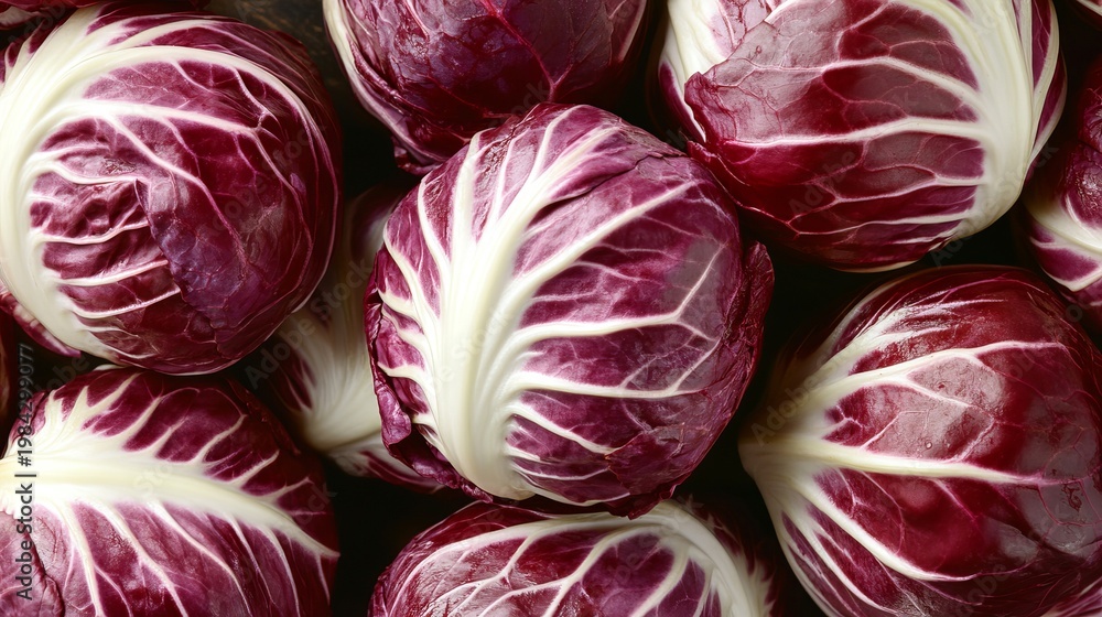 Obraz premium Crisp and Vibrant Crimson Radicchio Rosettes Displayed in a Fresh Produce Market Setting
