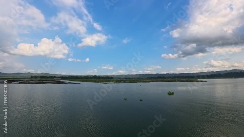 Aerial view of Sutami Dam at sunset with golden reflections on the reservoir water